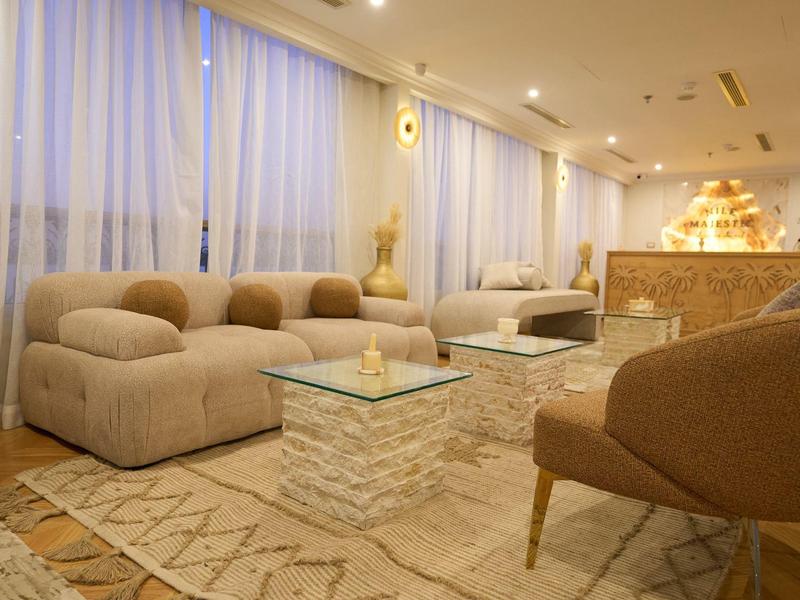 Acogedora sala de hotel con sofás cómodos, sillones, alfombra y luz cálida.