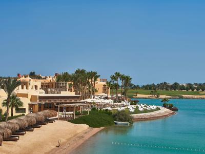 Spiaggia di sabbia fine con ombrelloni di paglia e alloggi confortevoli vicino a acqua turchese.