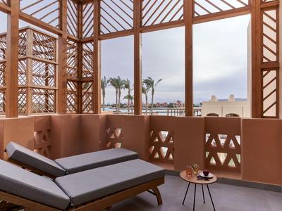 Terrazza dell'hotel con comodi lettini, vista mare e decorazioni in legno.