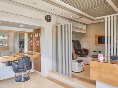 Sala trattamenti spaziosa con poltrona massaggiante e toeletta luminosa.