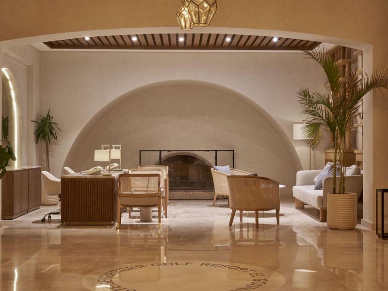 Salotto elegante con poltrone comode, camino e piante, atmosfera calda e accogliente.