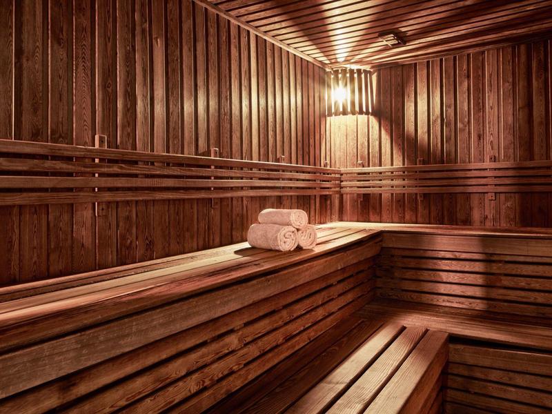 Interno di una sauna in legno con asciugamani piegati sulla panca.