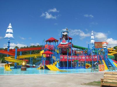 Parco giochi acquatico colorato con scivoli e irrigatori sotto un cielo blu