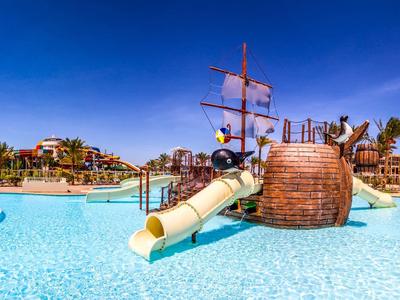 Piscina con scivolo a forma di nave pirata sotto un cielo blu.
