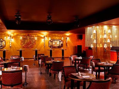 Stylische Hotelbar mit warmem Licht, Holzmöbeln und gemütlichen Sitzbereichen.