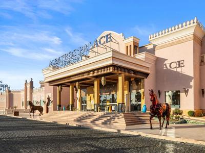 Edificio con columnas y gran entrada bajo cielo despejado, persona a caballo al frente