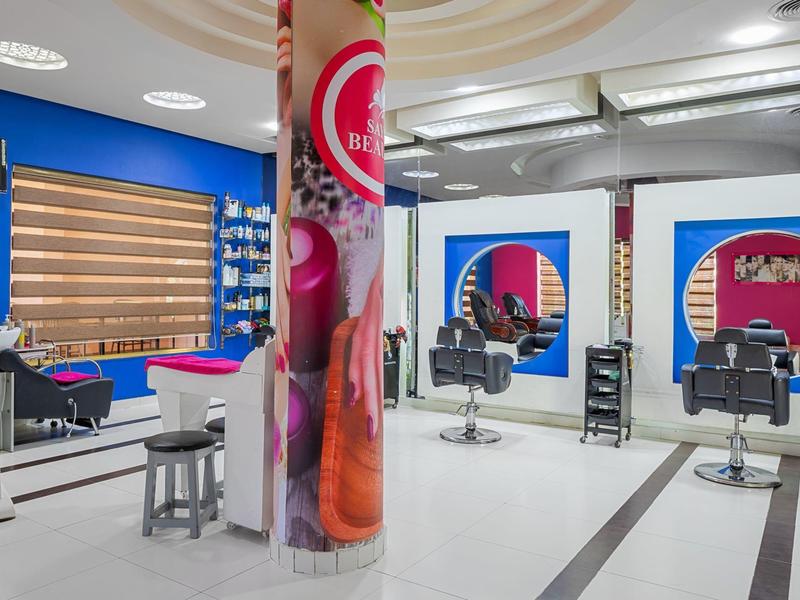 Salone di bellezza moderno con sedie nere e pareti blu e bianche.