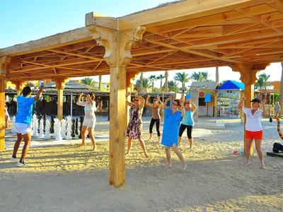 Kinder spielen unter einem Holzpavillon am Strand bei sonnigem Wetter