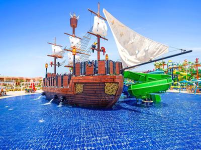 Parco acquatico con nave pirata e scivoli d'acqua sotto il sole.