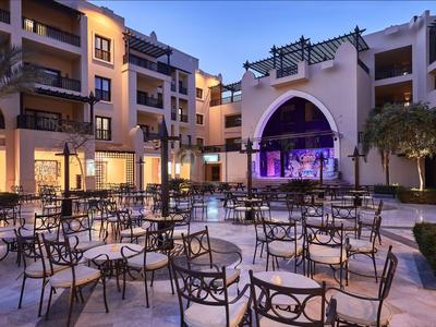 Innenhof eines Hotels mit Veranstaltungsbühne und Sitzgelegenheiten bei Abenddämmerung