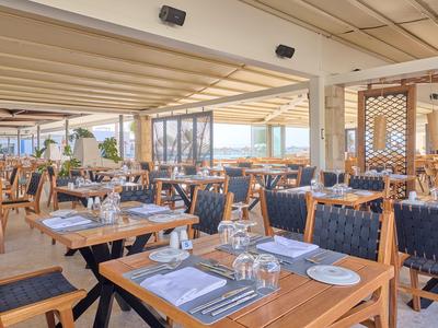 Helles Restaurant mit Holz- und blauen Polstermöbeln und Meerblick