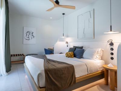Camera da letto con letto ampio, illuminazione moderna e design minimalista.