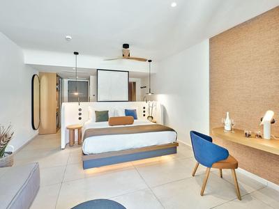 Camera d'hotel moderna con letto grande, scrivania e sedia comoda.
