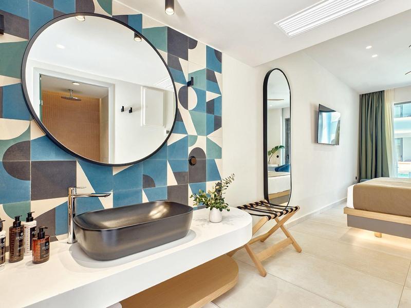 Modern hotel room with stylish sink and geometric wall decoration