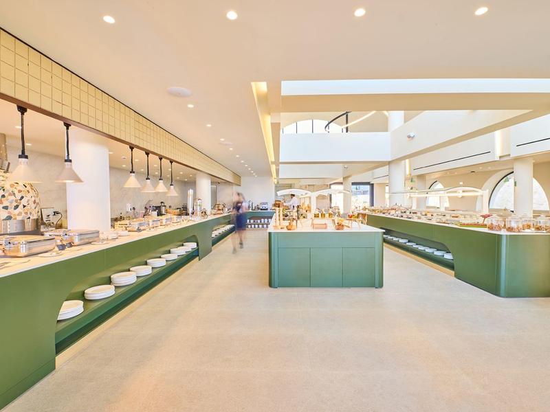 Modern, spacious breakfast area with long green buffets and bright ambiance.
