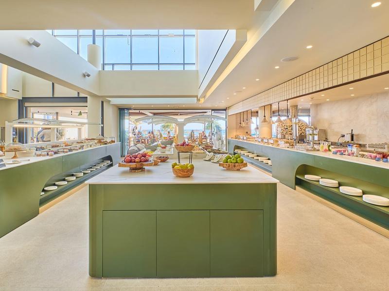 Bright, modern buffet area with green central island and large window