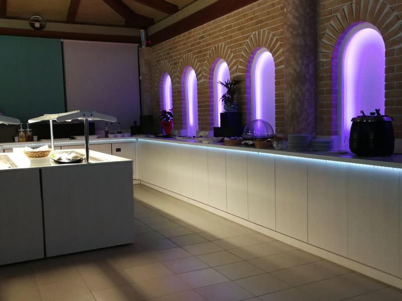 Buffet moderno con vitrinas iluminadas y ventanas de arco en sala elegante