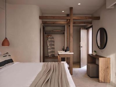 Eenvoudige hotelkamer met bed, houten meubels en neutraal kleurenpalet.