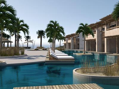 Complexe hôtelière de luxe avec piscine, palmiers et vue sur la mer par ciel dégagé.