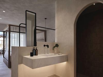 Miroir de salle de bain moderne avec lavabo et éclairage apaisant dans une chambre d'hôtel.