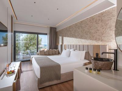 Moderne hotelkamer met tweepersoonsbed, balkonuitzicht en stijlvolle inrichting.