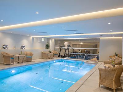 Moderner Innenpool mit Loungemöbeln und sanfter Beleuchtung in einem Hotel