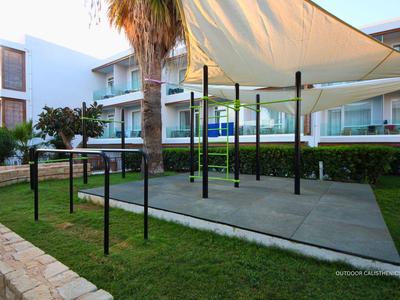 Moderner Hotelgarten mit schattigem Sitzbereich und Grünflächen.