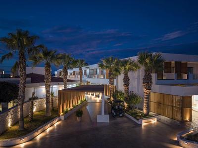 Hotel moderno con palmeras e iluminación nocturna