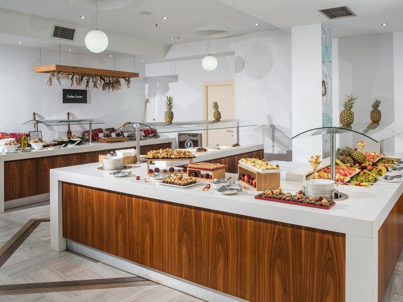 Buffet moderno de hotel con variedad de platos en un ambiente elegante y luminoso.