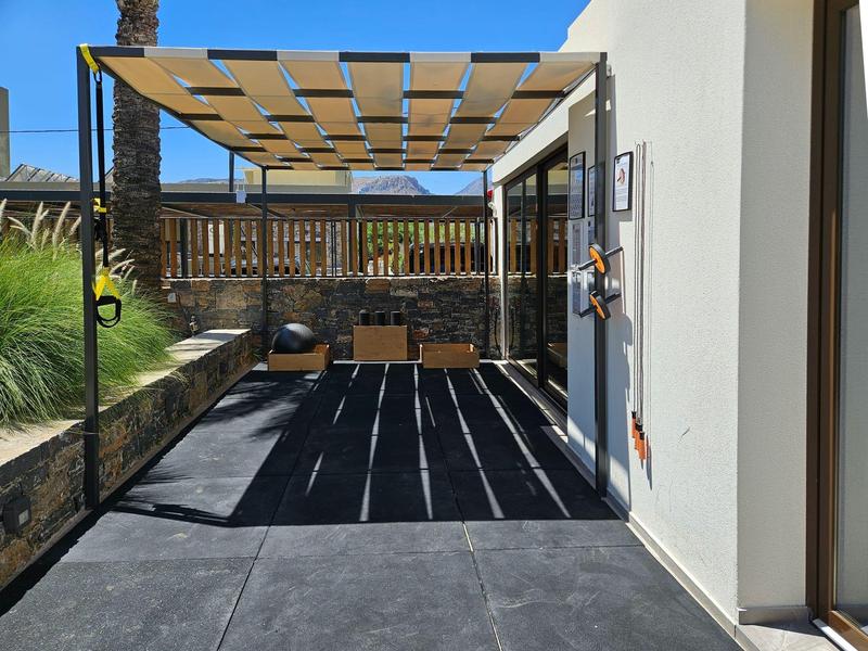 Espace extérieur moderne avec pergola, ombre et fenêtres en bois sur mur blanc