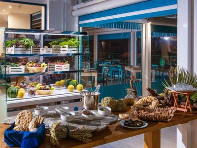 Buffet with fresh fruit and bread in a hotel restaurant overlooking a terrace.