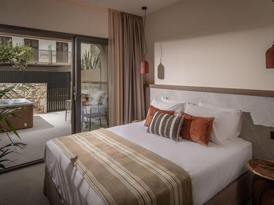 Schlafzimmer mit Doppelbett, Teppich, Pflanzen und Balkon mit moderner Einrichtung.