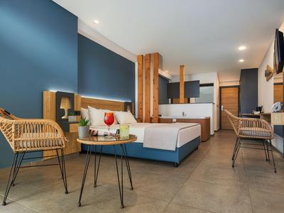 Camera d'hotel moderna con letto matrimoniale, parete blu e mobili eleganti.