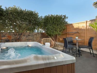 Vasca idromassaggio moderna con acqua frizzante e zona pranzo su una terrazza.