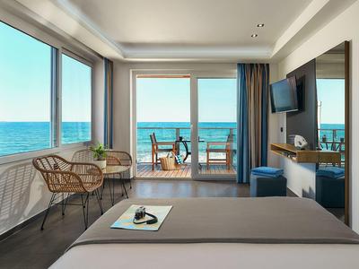 Camera d'hotel moderna con vista sul mare e balcone con sedie