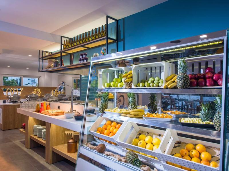 Fresh fruit displayed in a lit shelf in a hotel breakfast area.