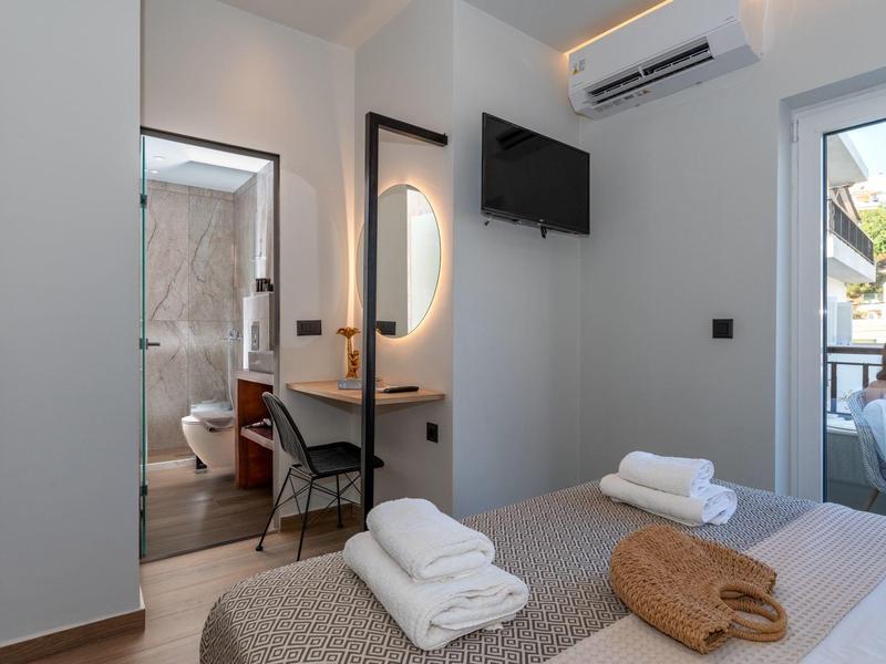 Modernes Hotelzimmer mit zwei Einzelbetten, Handtüchern und Sicht auf Badezimmer und Balkon.