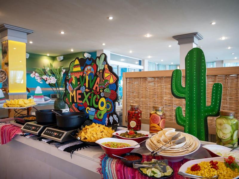 Bufet z meksykańskimi potrawami i dekoracjami w jasnym, nowoczesnym pomieszczeniu.