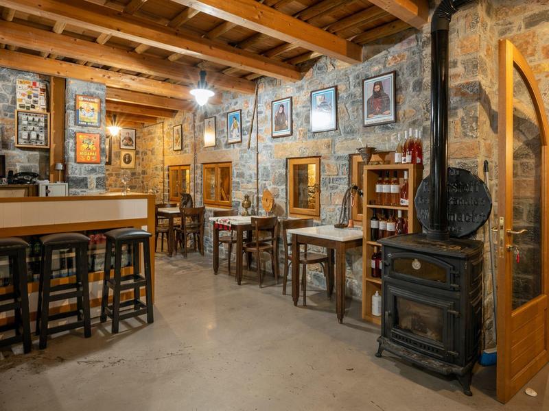 Rustykalna restauracja z drewnianym sufitem z belek, kamiennymi ścianami i drewnianymi meblami