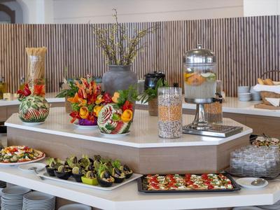 Buffet met diverse voorgerechten en vers fruit in een modern hotelrestaurant.