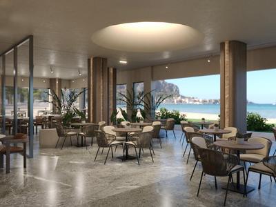 Modern hotelrestaurant met grote ramen en zeezicht bij daglicht.