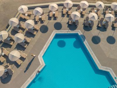 Luchtfoto van een hotelzwembad met omringende parasols en ligstoelen.