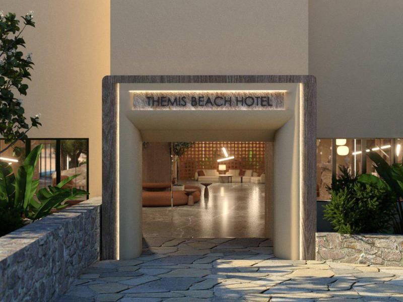 Entrada a un hotel boutique moderno con camino de piedra y plantas a los lados