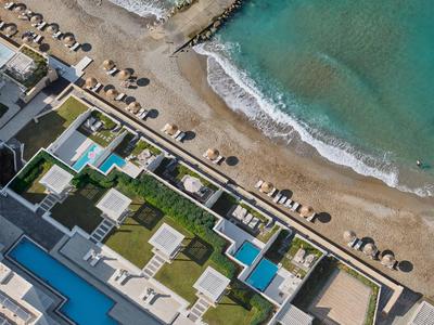 Veduta aerea di un hotel con piscine situato direttamente sulla spiaggia e mare turchese.