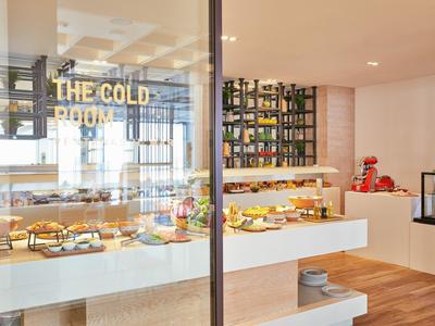 Nowoczesny hotelowy salon z starannie ułożonym bufetem śniadaniowym i drewnianą podłogą