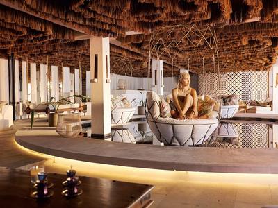 Nowoczesny salon z wygodnymi miejscami do siedzenia i dekoracyjnym drewnianym sufitem w hotelu.