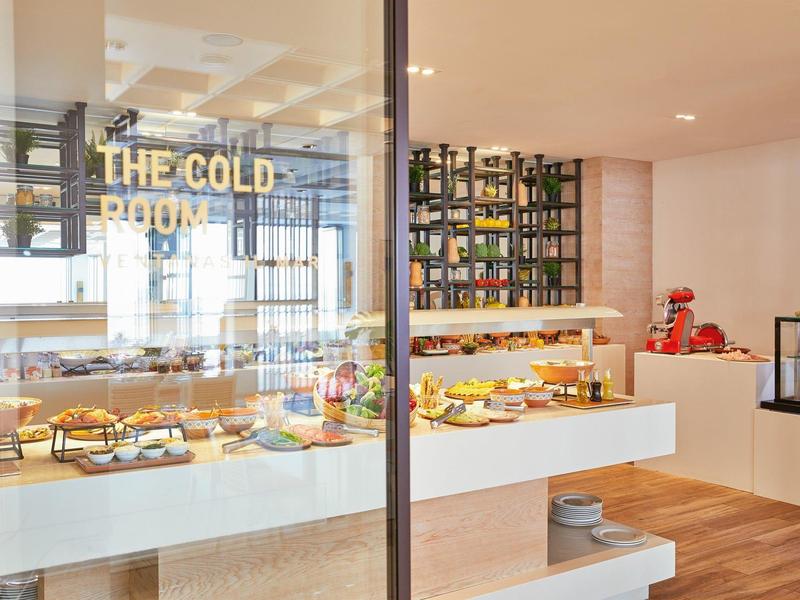 Nowoczesny hotelowy salon z starannie ułożonym bufetem śniadaniowym i drewnianą podłogą