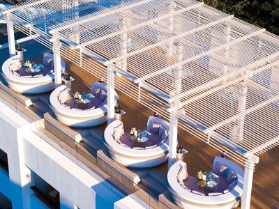 Terraza en la azotea con áreas de descanso redondas y pérgola en un hotel
