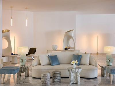Soggiorno moderno con divani comodi, illuminazione indiretta e cuscini decorativi.