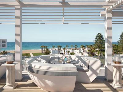 Terrazza aperta con vasca idromassaggio rotonda con vista su spiaggia e mare.